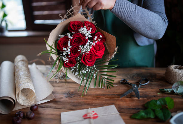 florista organiza flores de rosa vermelha - rose valentines day bouquet red - fotografias e filmes do acervo