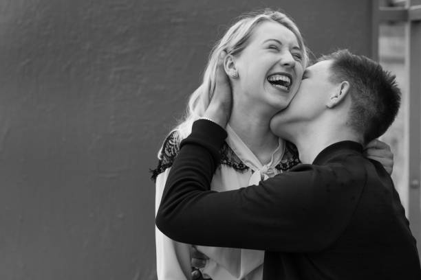 istock Young couple kissing sitting at bench at bus stop 1287767842