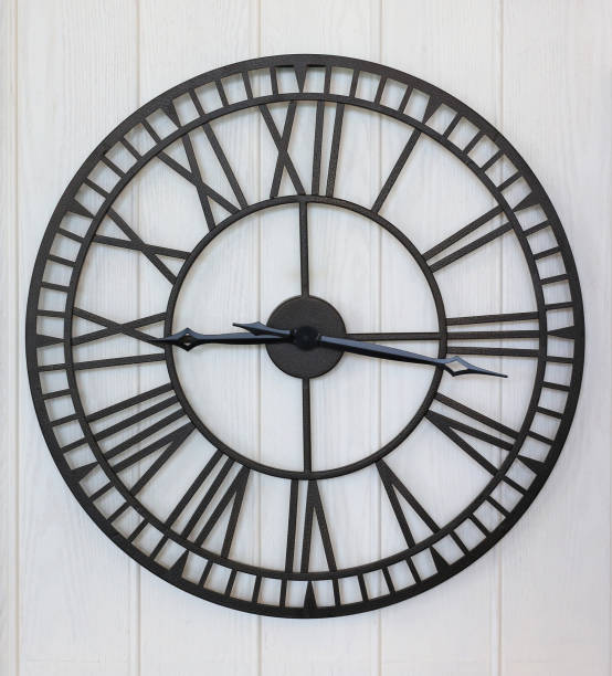 istock antique style clock on white wood plank wall background 1287776362