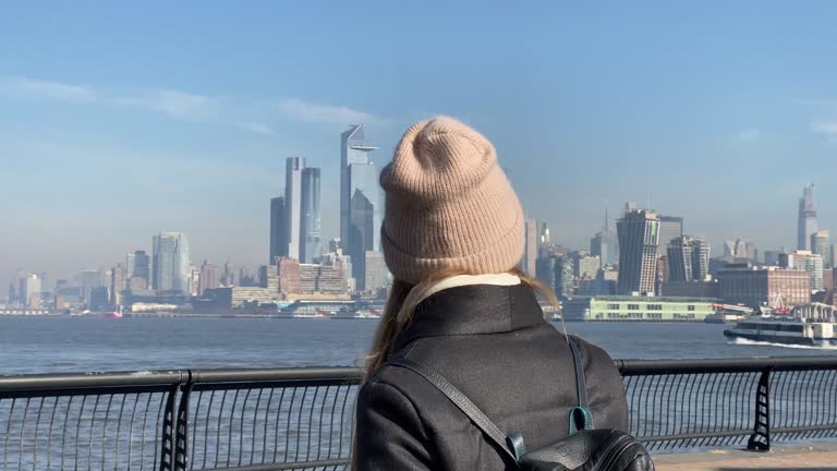 A young girl walking along the pier on a sunny cold day