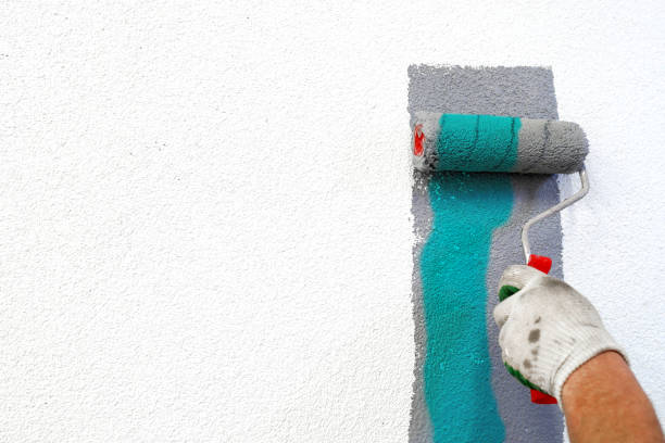 istock hand with paint roller in hand, painting a wall 1287779424