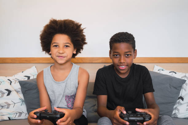 istock Two brothers playing video games at home. 1287785542