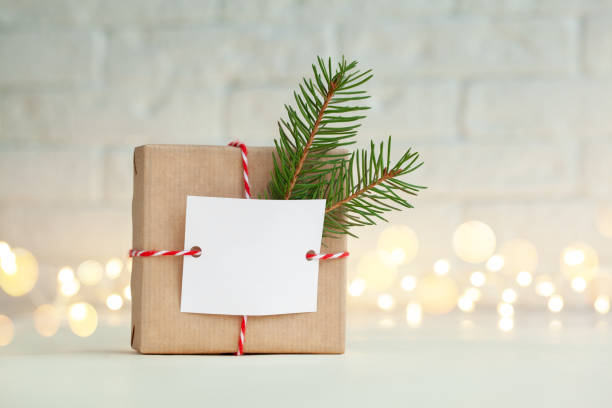 Christmas handmade gift box decorated with evergreen branch and empty blank gift card. New Year concept. stock photo
