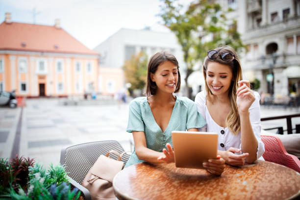 istock Beautiful friends in a cafe using tablet pc and having fun 1287788897