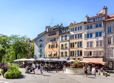 Geneva, Switzerland - September 5, 2020: The place du Bourg-de-Four is a busy and popular pedestrian square in the upper part of the old town, lined with old townhouses and sidewalk cafes.