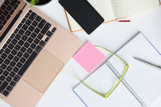 istock On table laptop smartphone glasses pen and notepad. 1287793531