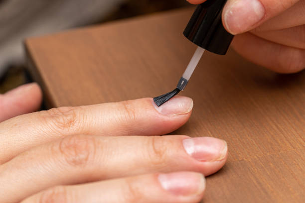 istock Applying primer, colorless nail polish with brush on finger 1287794596