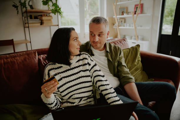 istock Young man and woman arguing while making an online purchase transaction using laptop at home 1287795268