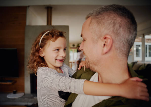 istock Young father holding girl child in hand while looking at each other 1287795579