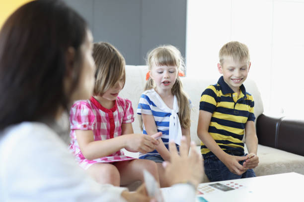 istock Woman and three children are playing board game. 1287796962