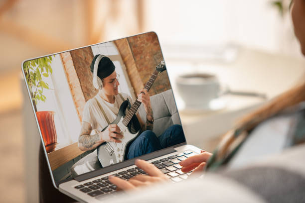 istock Close-up young woman learning play on musicial instruments online. 1287797407