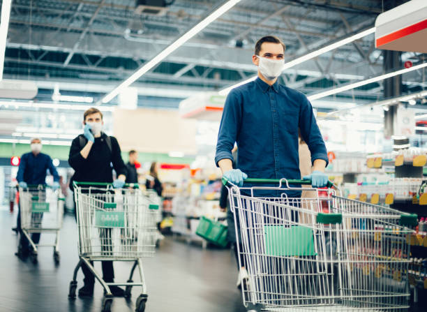 istock young man in a protective mask with a shopping cart 1287800052