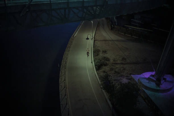 istock Cityscape at night with man riding a bike 1287802995