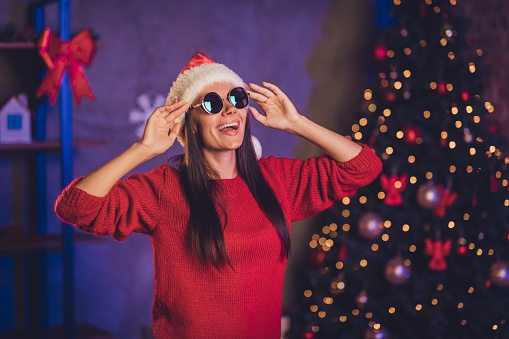 Photo of young happy smiling beautiful attractive joyful woman wear sunglasses santa claus hat celebrate new year at home house