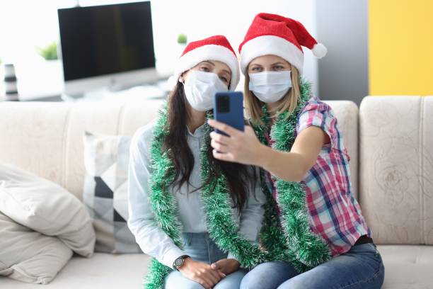 istock Two woman in protective mask take selfie on phone. 1287803575