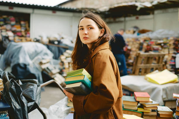 femme achetant des livres sur le marché de livre de cru - library young adult bookstore people photos et images de collection