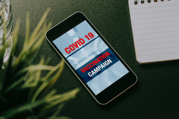 istock Covid 19 vaccination campaign design in a mobile phone screen. 1287804449