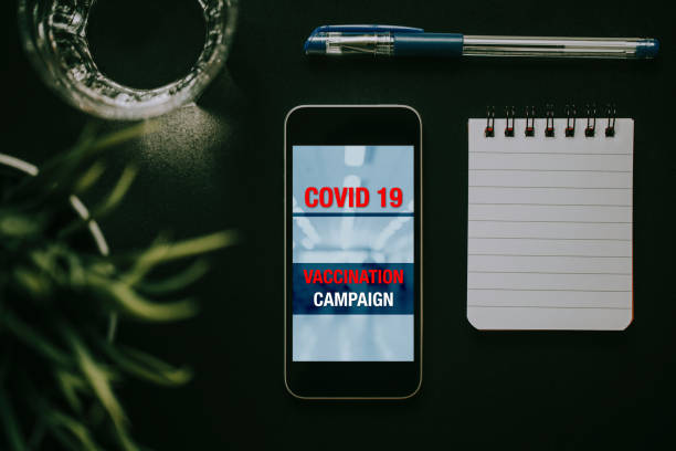 istock Covid 19 vaccination campaign design in a mobile phone screen. 1287804459