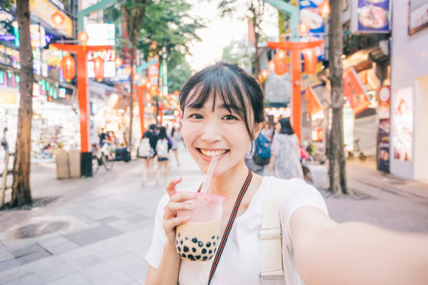 Young Asian woman taking a selfie Point of view image of Taiwanese woman taking a selfie. She's looking at the camera, drinking bubble tea. bubble tea photos stock pictures, royalty-free photos & images