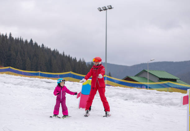 istock The child learns to ski with the instructor. 1287806808