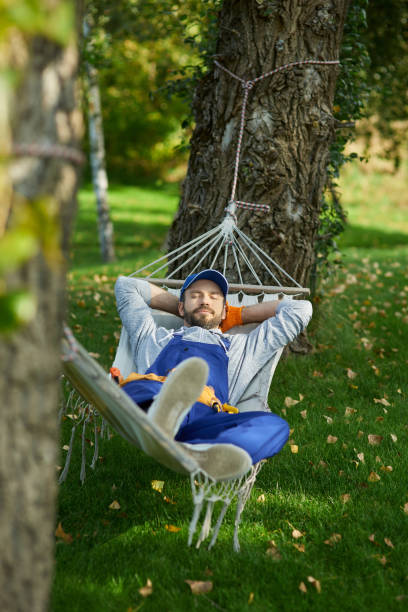 istock Peaceful young workman wearing uniform taking a break, lying in a hammock outdoors with eyes closed on a sunny day 1287808526
