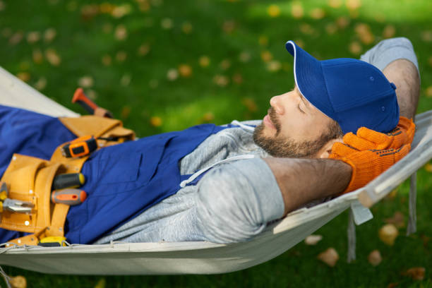 istock Peaceful young male builder wearing uniform taking a break, lying in a hammock outdoors with eyes closed on a sunny day 1287808537