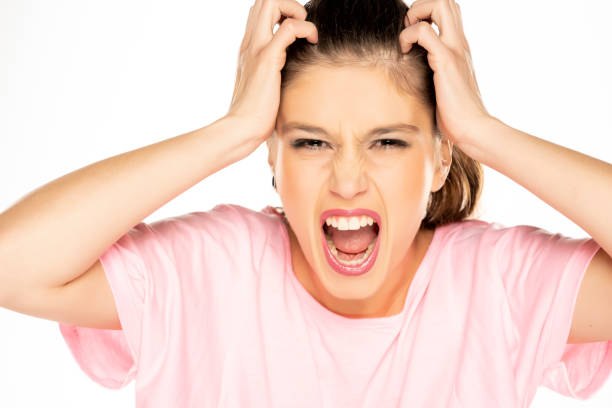 portrait of young nervous woman scratches her head portrait of young nervous woman scratches her head on white background creaming stock pictures, royalty-free photos & images