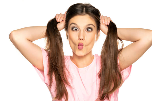 istock Young funny woman with ponny tails make a faces on white background 1287811312
