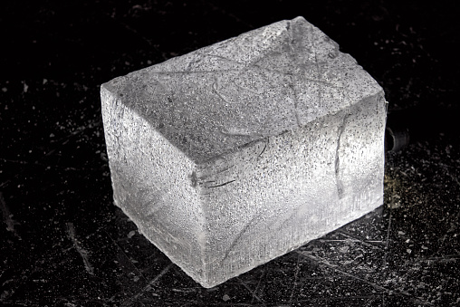 White sugar and refined sugar cubes on a black background