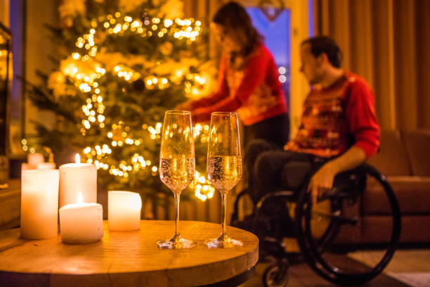 Beautiful differently abled young wheelchair couple enjoying the xmas festivities dressed up in fun onesies in a family home adorned with christmas decorations