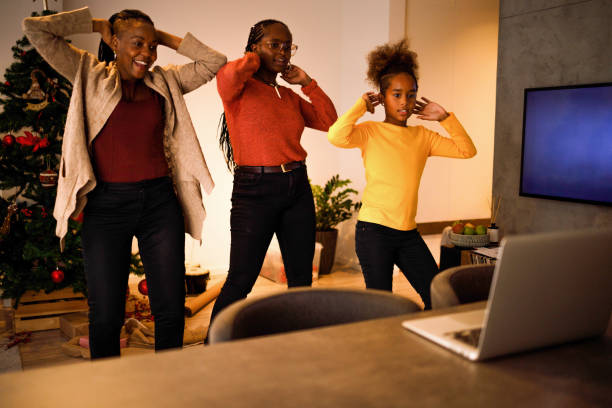 Tap tok Three female members of an African American family have lots of fun dancing Tik Tok routines on Christmas day. moving image stock pictures, royalty-free photos & images