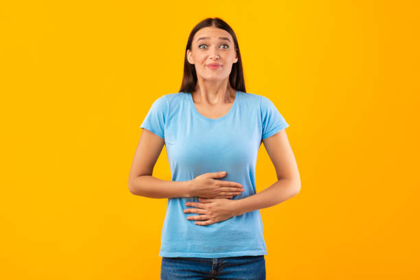 young satisfied woman touching her stomach at studio - full contact imagens e fotografias de stock