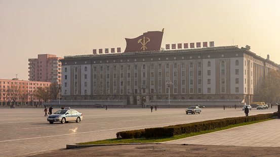 Pyongyang / DPR Korea - November 12, 2015: Kim Il-sung Square and government buildings decorated with flags and revolutionary slogans in Pyongyang, North Korea