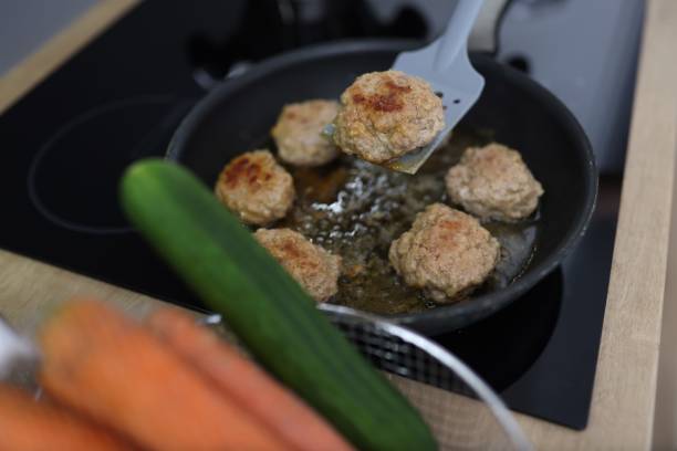 istock Chef uses spatula to flip over fried cutlets in kitchen closeup 1287825713