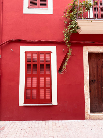 Detail of red window of traditional house, volcanic rock stone wall in Terceira island, Azores archipelago, Portugal.