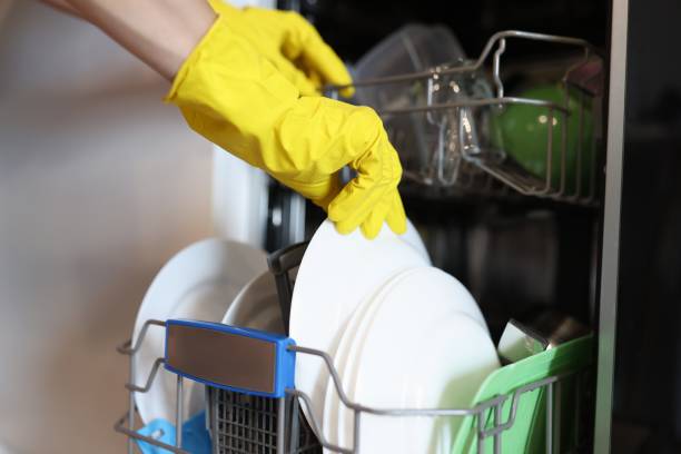 istock Hand in yellow glove take out washed kitchen utensil. 1287827597
