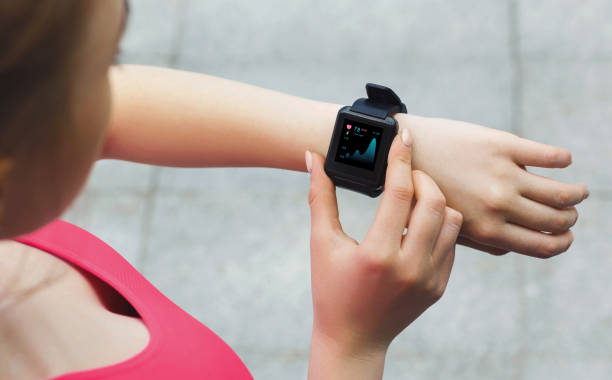 istock Modern training with device and activity monitoring. Over shoulder view of athletic lady using fitness tracker 1287827775