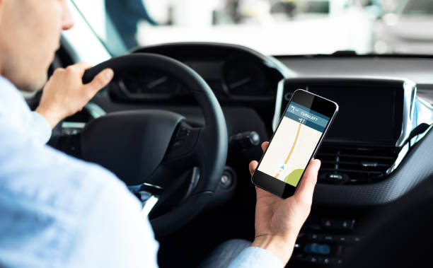 istock Driver Using Smartphone With Car Navigation App Driving In City 1287829015