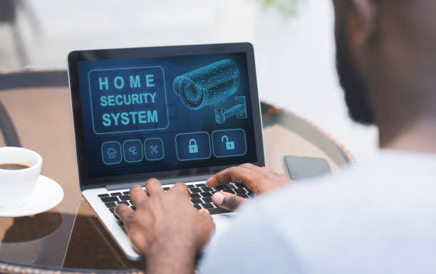 homem usando seu laptop com aplicativo de segurança doméstica - security system prevent lock crime - fotografias e filmes do acervo