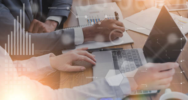 istock Colleagues with laptop and documents creating online project at office, collage with financial data on virtual screen 1287829509
