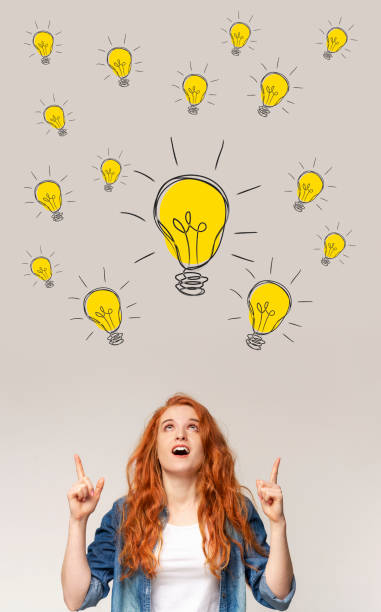istock Excited red-haired lady pointing up at light bulbs, collage. Creativity and inspiration, finding innovative solutions 1287830209