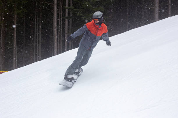istock The snowboarder goes down the ski slope. 1287831036