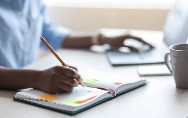 istock Busy Unrecognizable Woman Writing In Notepad, Taking Notes At Workplace In Office 1287831890