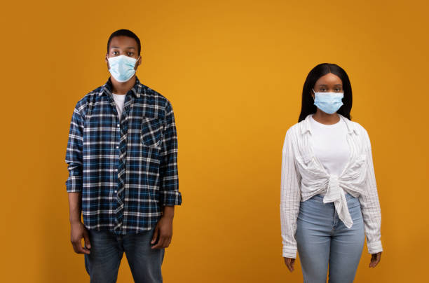 istock Sad young african american male and female in protective masks keep range 1287832413