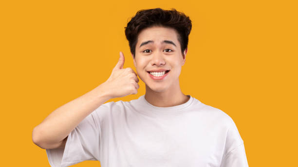 istock Happy asian man gesturing thumbs up and smiling 1287832536