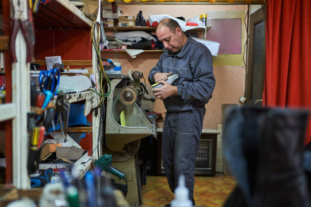 istock Cobbler using a ring binder to smooth a sole of sports shoe 1287833681