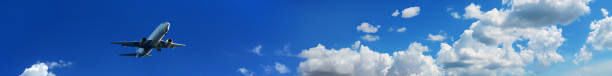 Flying commercial passenger airplane over blue sunny sky