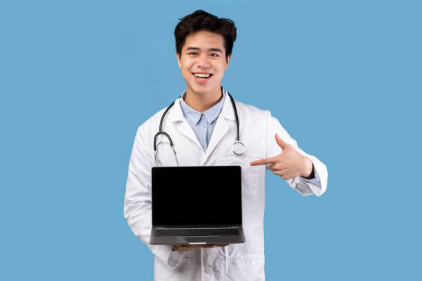 istock Asian medical practitioner holding laptop with empty screen 1287836570