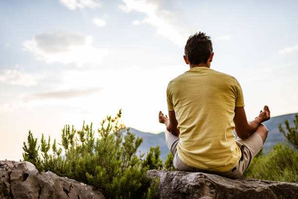 istock Young man preforms yoga in mountains at sunset 1287837582