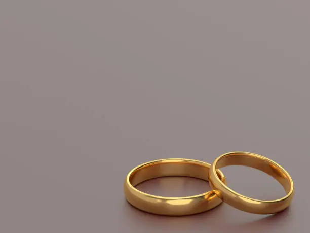Two wedding gold rings lie next to each other on grey background. 3d rendering